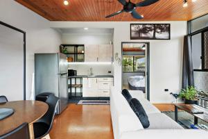a kitchen and living room with a couch and a table at Pukeko Guesthouse - Relax in Redcliffe in Redcliffe