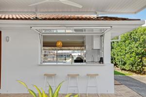 an outdoor bar with stools in front of a house at Saltwater Villas - Pet Friendly Accommodation in Mooloolaba