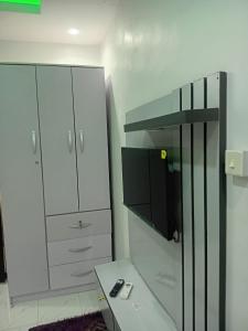 a room with a desk and a tv and a cabinet at Olori apartments in Adeleye