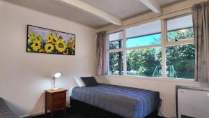 a bedroom with a bed in front of a window at Mount View Motel Hawera in Hawera