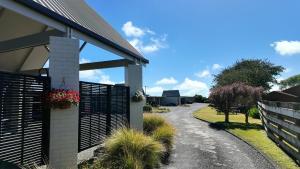 a house with a fence and a driveway at Mount View Motel Hawera in Hawera