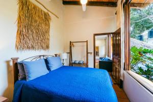 a bedroom with a blue bed and a window at Amare Las Villas in Sayulita