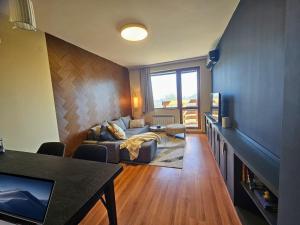 a living room with a couch and a table at One-Bedroom Apartment with Balcony & Fast WiFi in Bansko