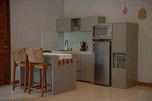 a kitchen with stainless steel appliances and bar stools at Villa Kelapa Candidasa in Candidasa
