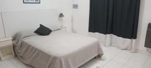 a bedroom with a bed with a black pillow on it at Casa Sofía in Paraná