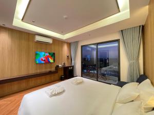 a hotel room with a bed and a tv at Carista Hotel in Vientiane
