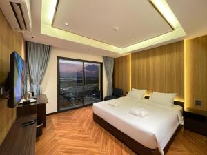 a bedroom with a large bed and a large window at Carista Hotel in Vientiane +60 photos