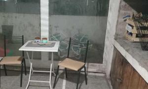a table with two chairs and a table with two cups on it at Casa Sofía in Paraná