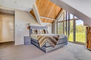 a bedroom with a bed and large windows at Duinvilla Noordwijk in Noordwijk