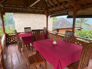a dining room with two tables with purple table cloth at Villas Ume Sedani in Sidemen +55 photos