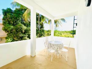 a dining room with a table and chairs and a window at MLQ Apartments by Avi in Grand-Baie