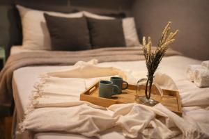 a tray with two cups and a vase with flowers on a bed at The Birthplace of Samba Carioca in Rio de Janeiro
