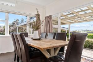 a dining room with a wooden table and chairs at Sunset Villa in Martinborough
