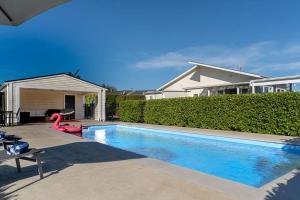 a swimming pool in front of a house at Sunset Villa in Martinborough