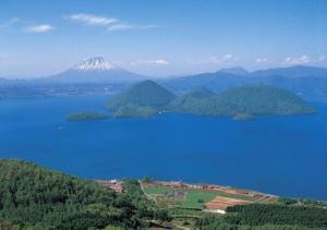 an island in a body of water with a mountain at ウーノ洞爺湖 in Abuta