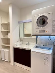 a kitchen with a washing machine and a sink at Akikawa Koshi 13 新築木造一棟貸切ヴィラ in Yuge +13 photos
