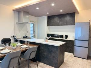 a kitchen and dining room with a table and chairs at Akikawa Koshi 13 新築木造一棟貸切ヴィラ in Yuge