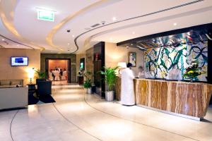 lobby hotelu z kobietą stojącą przy ladzie w obiekcie Landmark Grand Hotel w Dubaju