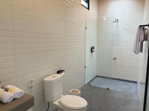a white bathroom with a toilet and a shower at Umah Sepur Villa in Dalung +4 photos