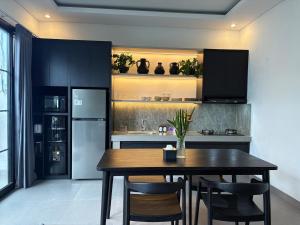 a kitchen with a table and chairs and a refrigerator at Umah Sepur Villa in Dalung