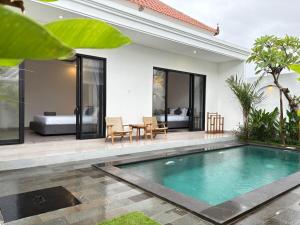a villa with a swimming pool and a bedroom at Umah Sepur Villa in Dalung
