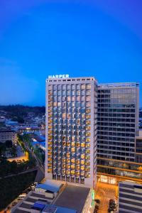 a tall building with a hotel sign on top of it at Harper Premier Nagoya Batam in Nagoya