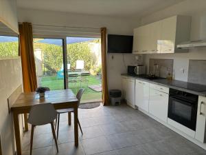 a kitchen with a table and a table and a dining room at Studio tout équipé à la nuitée ou plus,proche aéroport Bastia in Lucciana