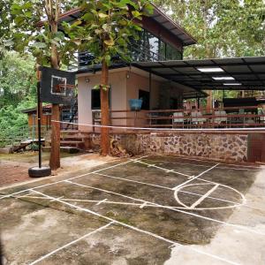 a tennis court in front of a building at ดงสัก สไตล์ป่า ไทรโยคน้อย in Ban Phu Pla Kang