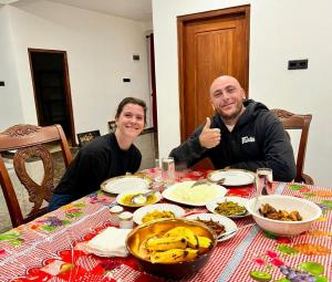 two people sitting at a table with food at River Side Guest House in Hatton