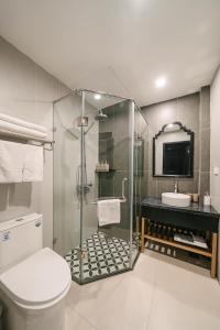 a bathroom with a shower and a toilet and a sink at Quatorze Hotel in Hanoi
