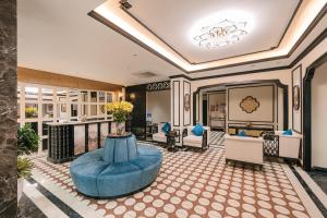 a lobby of a hotel with a blue ottoman at Quatorze Hotel in Hanoi