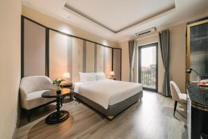 a hotel room with a bed and a chair at Quatorze Hotel in Hanoi