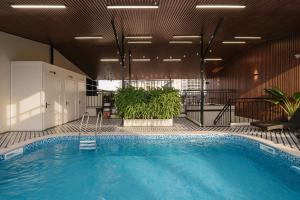 a large swimming pool in a building with plants at Quatorze Hotel in Hanoi +44 photos
