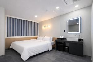 a hotel room with a white bed and a sink at JE JA RI Stay in Seoul