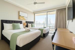 a hotel room with two beds and a balcony at L17 Small Studio Suite 2 Beds Pool Spa in Gold Coast