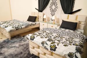 a bedroom with two beds withskirts at Proxima Quarters in Rawalpindi