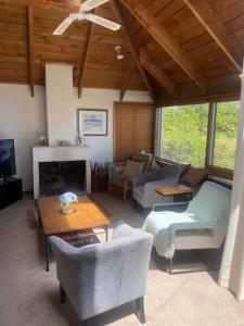 a living room filled with furniture and a fireplace at Beach side Waikanae Bach in Waikanae