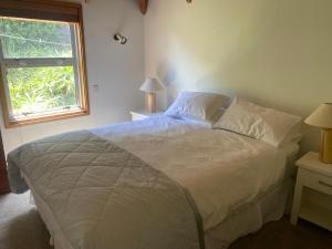 a bedroom with a large bed and a window at Beach side Waikanae Bach in Waikanae