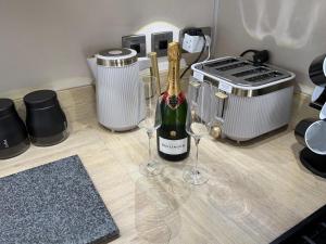 a bottle of wine sitting on a counter with two wine glasses at S&K Lodge Billing Aquadrome Holiday Park, Great billing ,Northampton , NN3 9DA in Northampton +15 photos