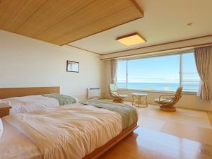 a bedroom with two beds and a large window at Shiretoko Daiichi Hotel in Shari