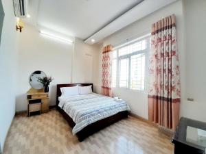 a bedroom with a bed and a window at Khách sạn Đông Tây Quy Nhơn in Quy Nhon