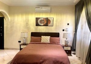 a bedroom with a large bed with two lamps at 3R Haven in Kumasi +21 photos