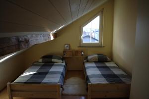 2 camas en una habitación pequeña con ventana en Apartments Place4you, en Bjelovar