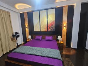 a bedroom with a purple bed with purple pillows at Bloomy villa in Hatton