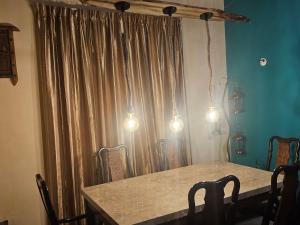 a dining room with a table and a curtain at Bloomy villa in Hatton