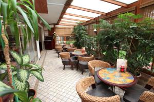 un patio extérieur avec tables, chaises et plantes dans l'établissement Güneş Hotel Merter, à Istanbul