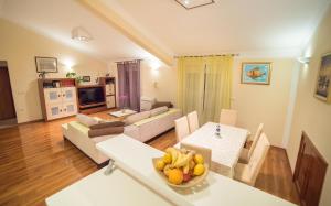 a living room with a table with a bowl of fruit at Captain's Apartment in Rab