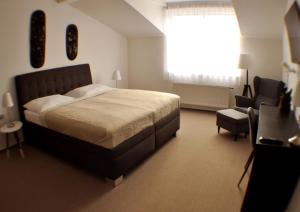 a bedroom with a bed and a chair and a window at Studia Letců 2A in Olomouc