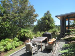 a patio with a wooden table and two chairs at Beaconstone - your perfect escape in Charleston