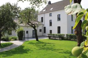 einen Blick auf ein weißes Haus mit einem Hof in der Unterkunft Landhotel Alte Töpferei in Duisburg
